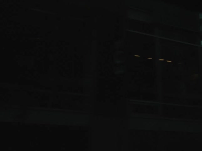A building in a city reflects another building in glass windows