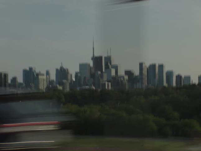 City skyline with tall buildings seen from a moving vehicle