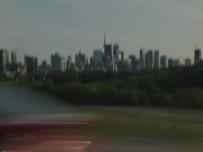Moving view of streets with vehicle traffic and skyscrapers of a metropolis in the background