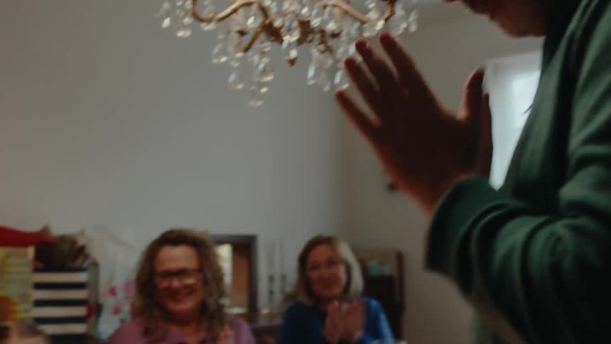 A happy family clapping at grandmothers birthday
