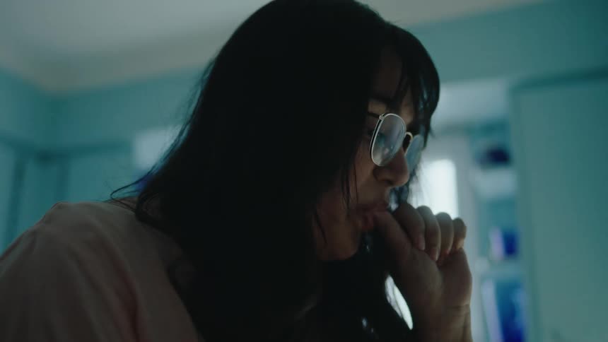 A woman tastes the food she is cooking