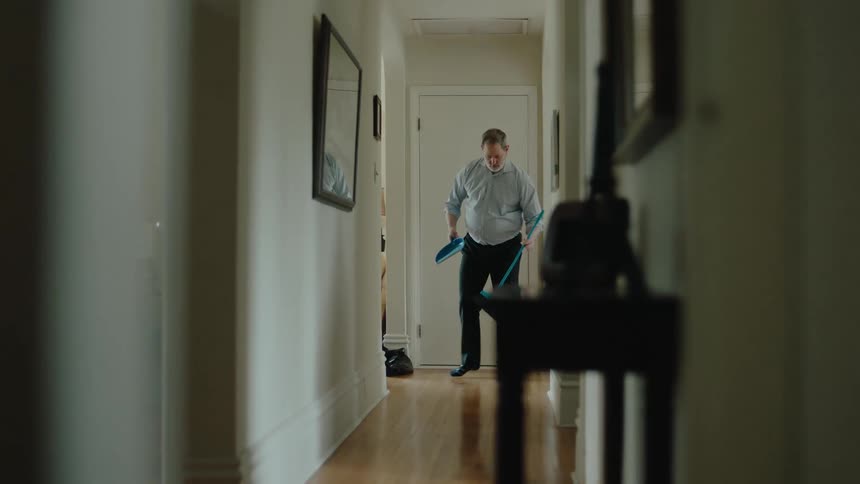 Man pulls broom out from the closet and sweeps the floor