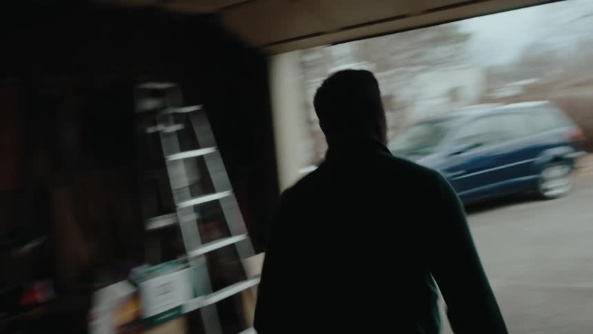 Desperate man leaving the garage and heading towards a woman who is driving a beetle