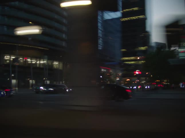A vehicle cruises through the downtown area of the city surrounded by towering skyscrapers