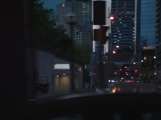 Crossroads of a metropolis at dusk with large buildings and pedestrians