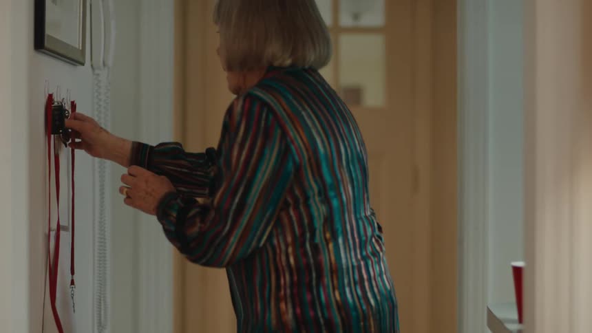 A woman picks up a key to open the apartment door