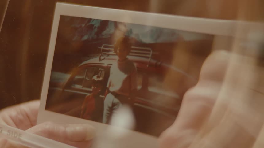 A person is using a magnifying glass to view a photo