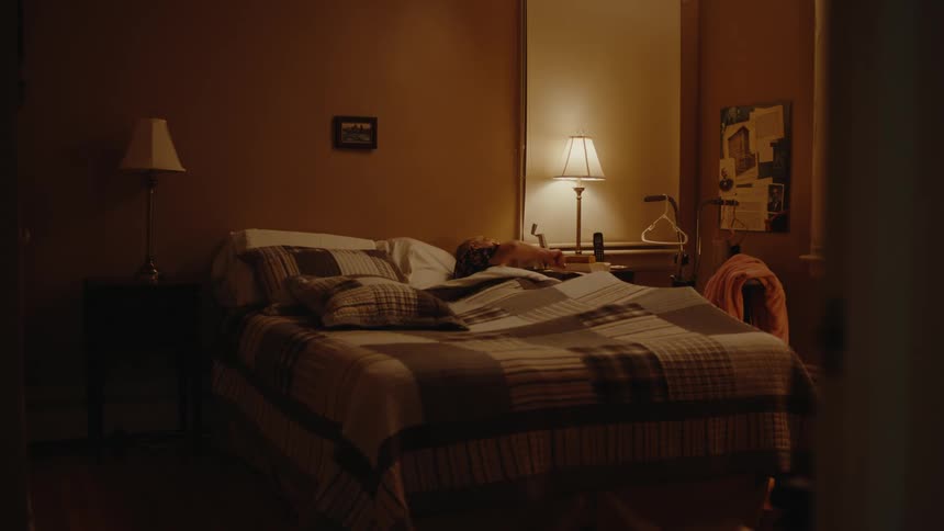 The elderly woman goes to bed and gazes at a photo in her bedroom