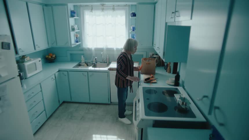 A woman is cutting vegetables in the kitchen