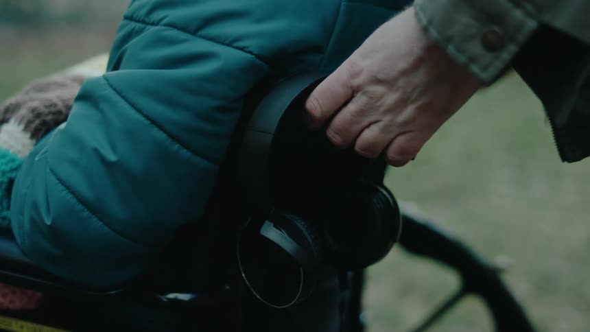 A man pushes a person in a wheelchair outdoors