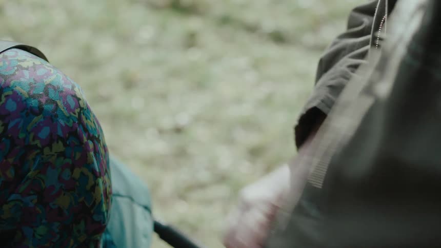 As the man holds a smartphone behind an elderly woman on a bicycle he looks at his heart rate displayed on the screen