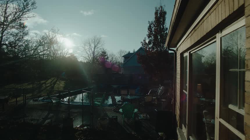 A backyard with a pool illuminated by the sun at morning