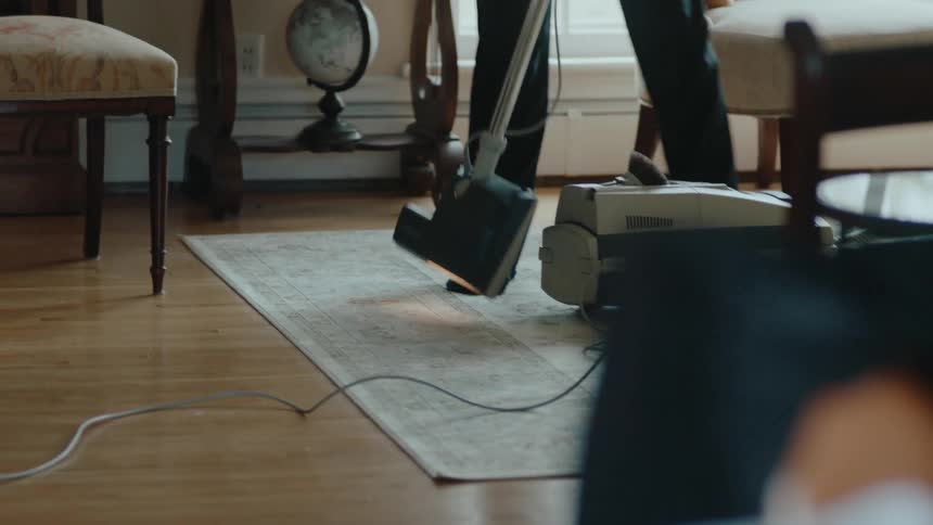 A man is vacuuming the rug