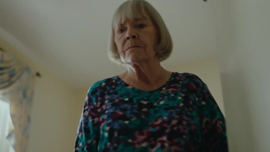 Elderly lady opening a closet door and throwing an object