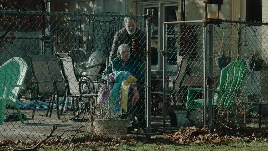 A man pushes a woman in a wheelchair