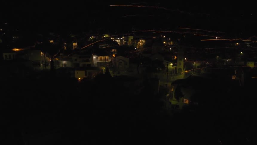 Fireworks are launched over a city at night