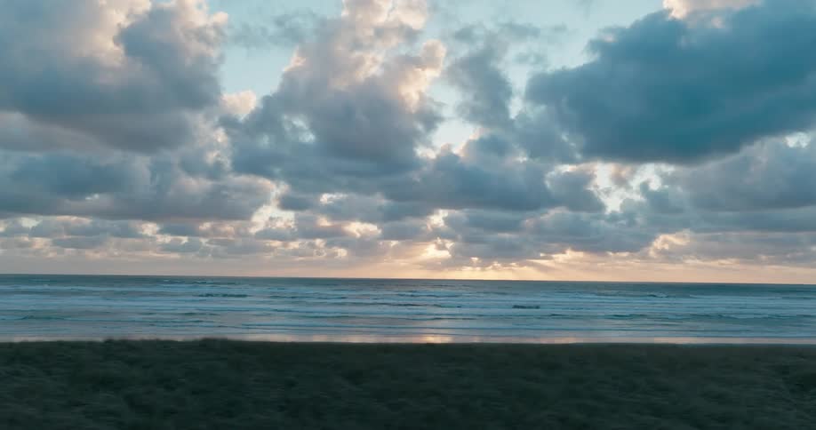 Clouds fill the sky above the ocean along a scenic coastline