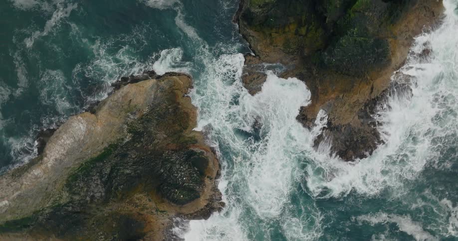 Aerial view of waves crashing on rocky shores