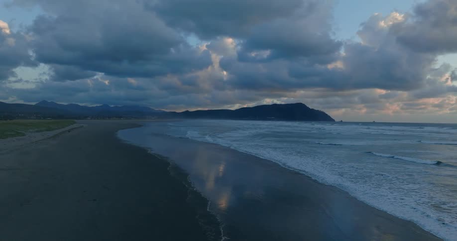 Aerial view of a beach with waves arriving on the sand on a morning with the sky with clouds