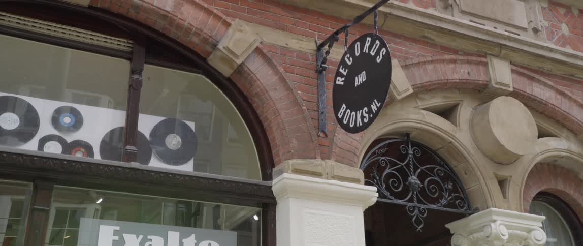 Sign for store selling records and books hangs outside the storefront