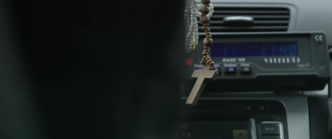 Interior of a vehicle with a rosary and a cross