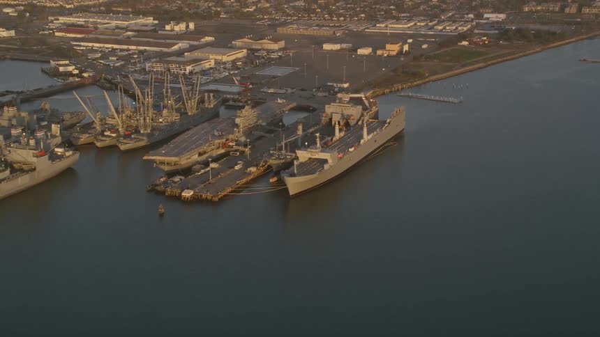 Naval vessels float near waterfront dock