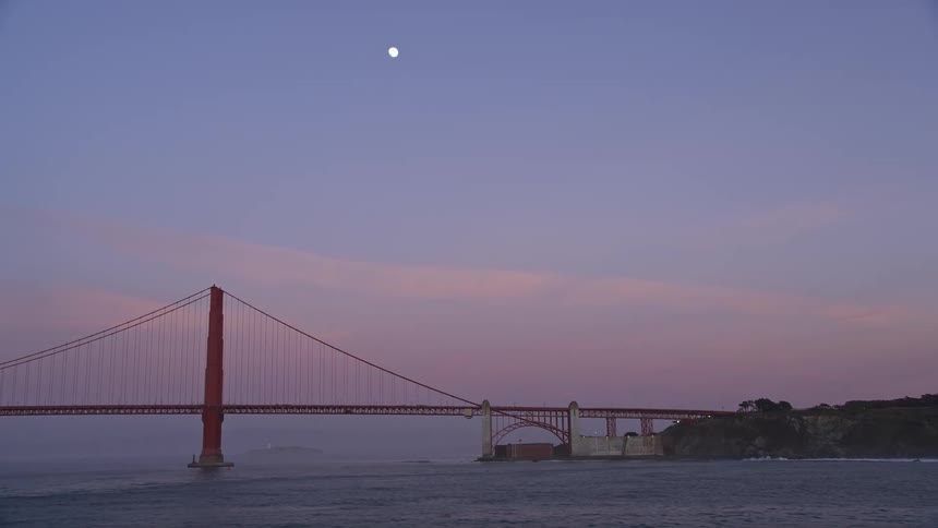 Golden gate bridge over a vast ocean with the moon in the purple sky