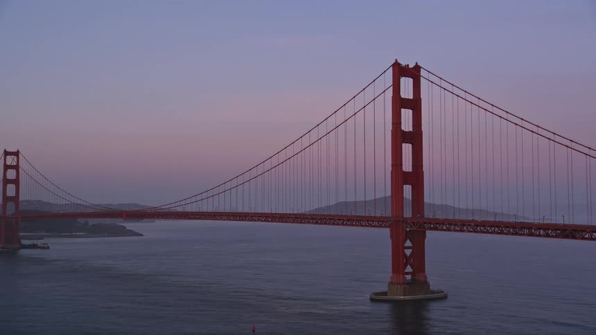 Traffic moves over a suspension bridge stretching across the water