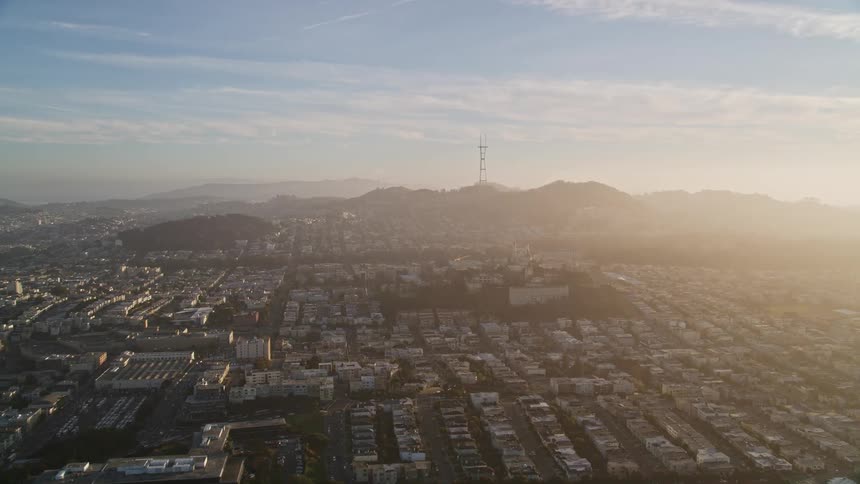 An aerial view captures a residential area in the city bathed in the warm glow of sunset