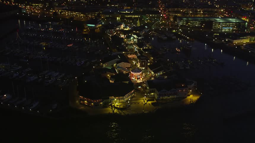 Panorama of a circus by the sea in a metropolis with skyscrapers in the background illuminated at night