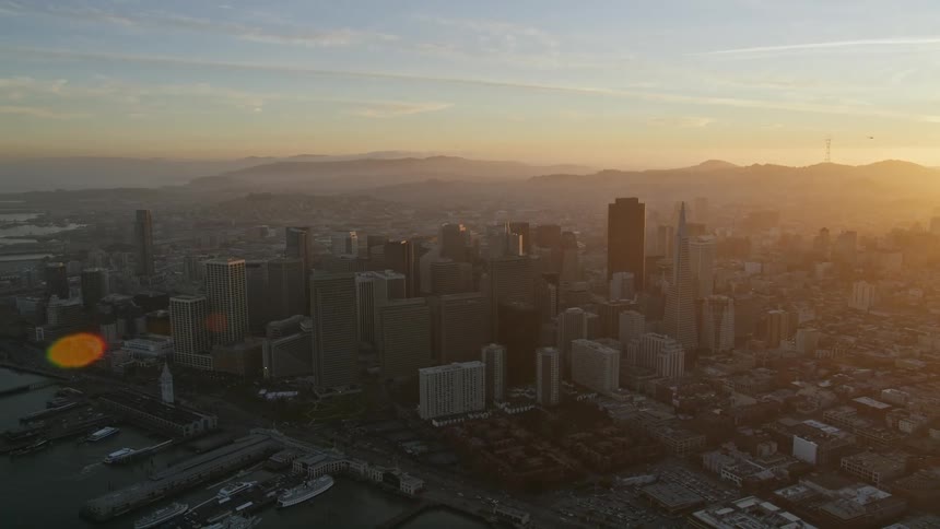 The sky is ablaze with color as the sun dips below the horizon casting a warm glow over the city skyline