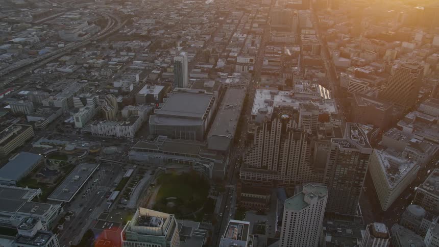 Metropolises with commercial buildings and urban areas by the sea and mountains on the horizon in a red sky morning