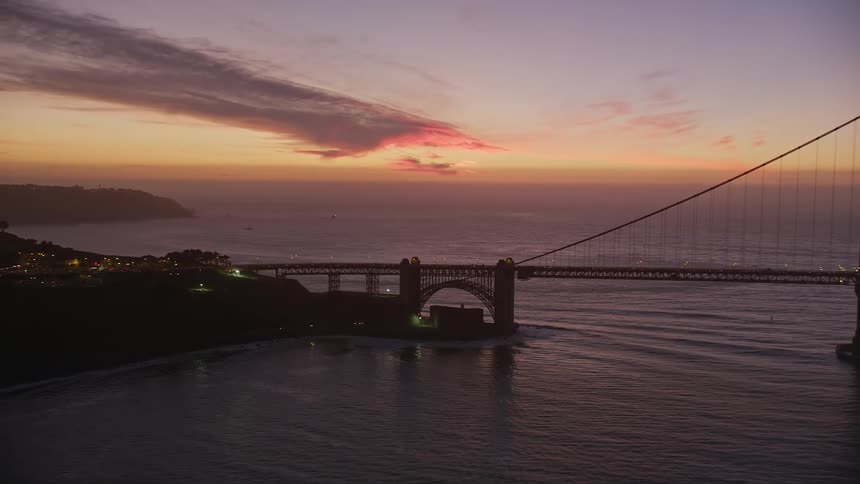 Aerial scenery of an extensive bridge over a vast sea on a red sky day