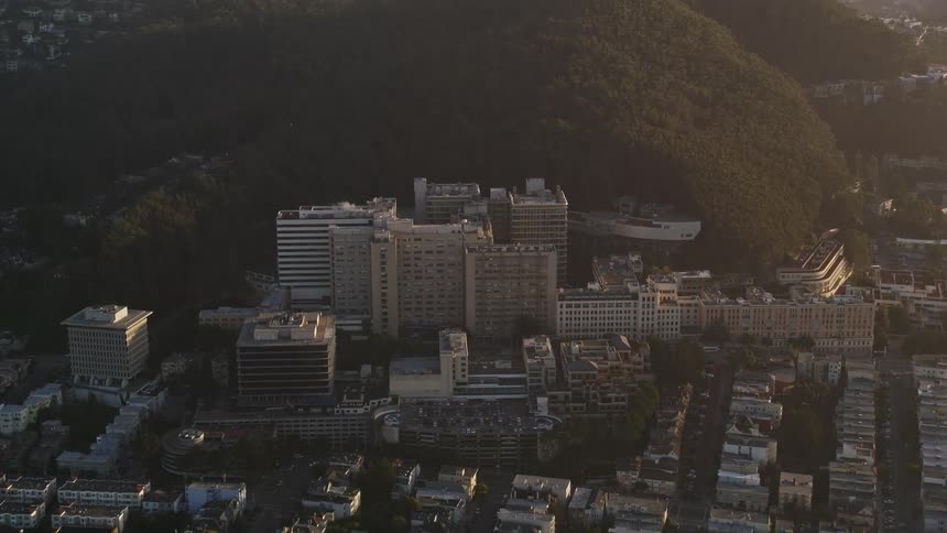 Aerial panorama of urban and commercial buildings on the edge of a wooded hill