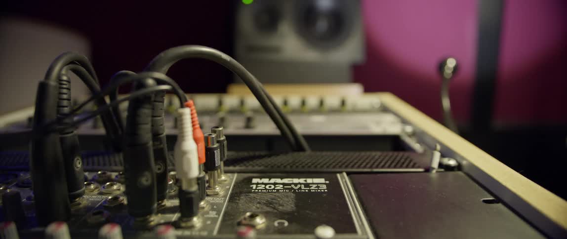 A closeup of audio equipment with knobs and cables a speakers