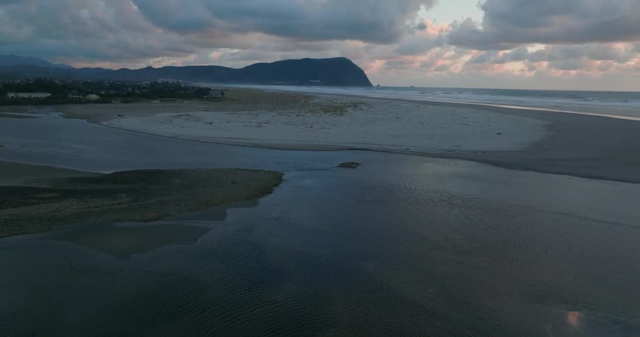 Aerial landscape of a beach with calm waters along the stretch of sand and in the background of the sea coast
