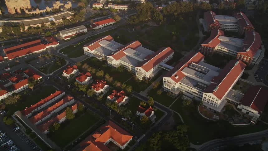 Highway traffic passes red roofed complex at the edge of the residential neighborhoods bordering downtown