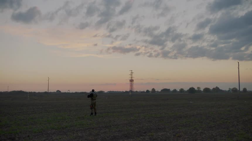 A soldier holds his rifle on the field