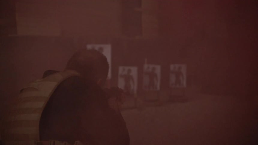 A person surrounded in smoke is shooting a gun with targets visible in the background