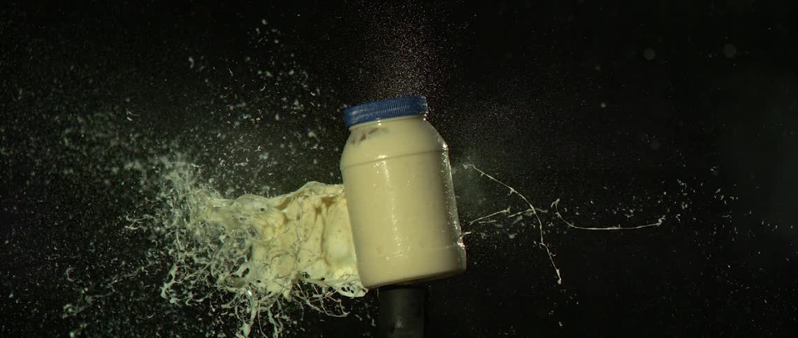 A bullet shatters a jar of mayonnaise in super slow motion, shot at 30,000 frames per second.