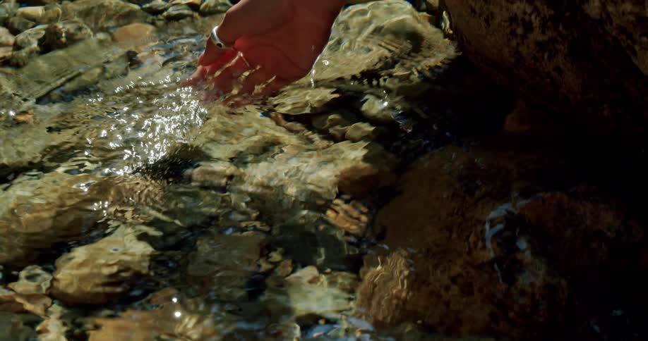 A person dips their hand in the water