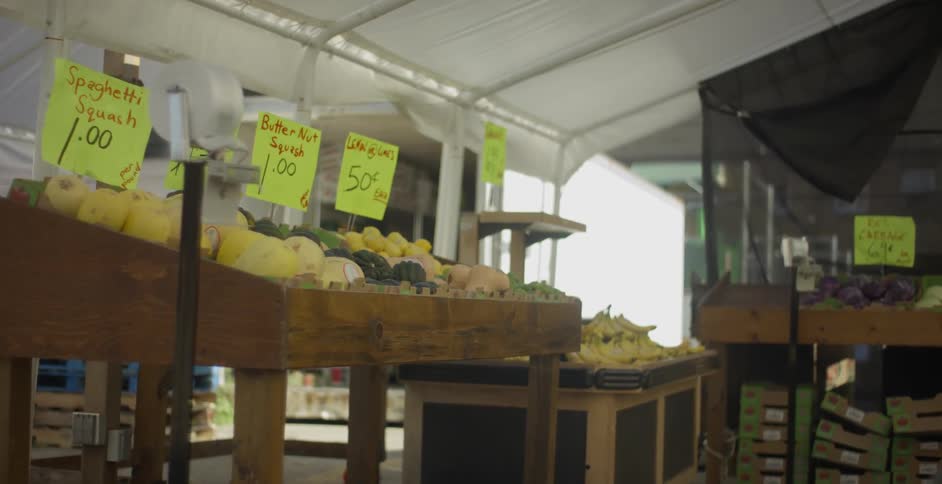 An indoor farmers market full of produce on a sunny day