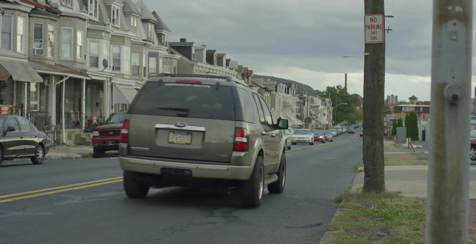 A bus and cars drive down a busy suburban street