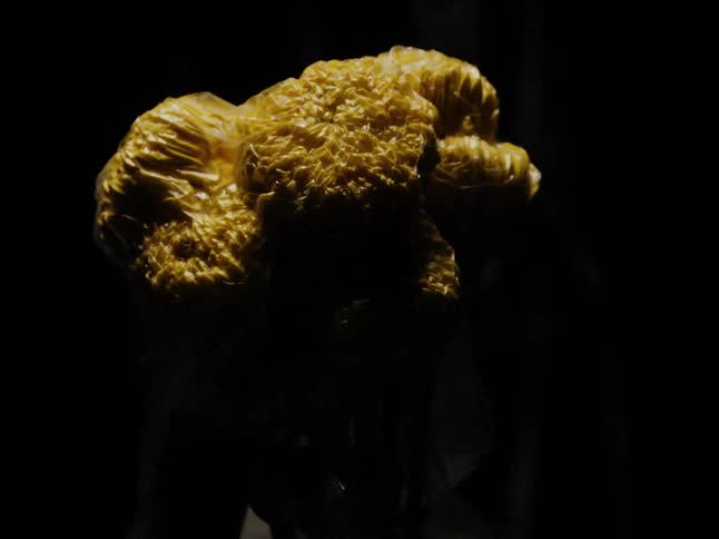 A yellow substance wrapped in plastic suddenly shrinks down in size