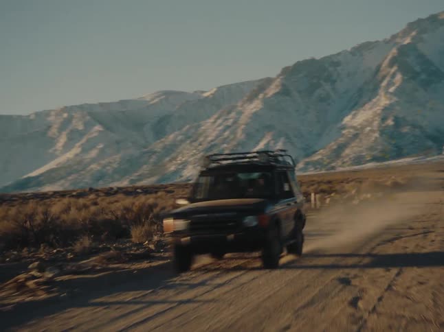 A vehicle is driving away from the mountain
