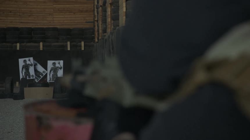 A person aiming and firing a gun at targets
