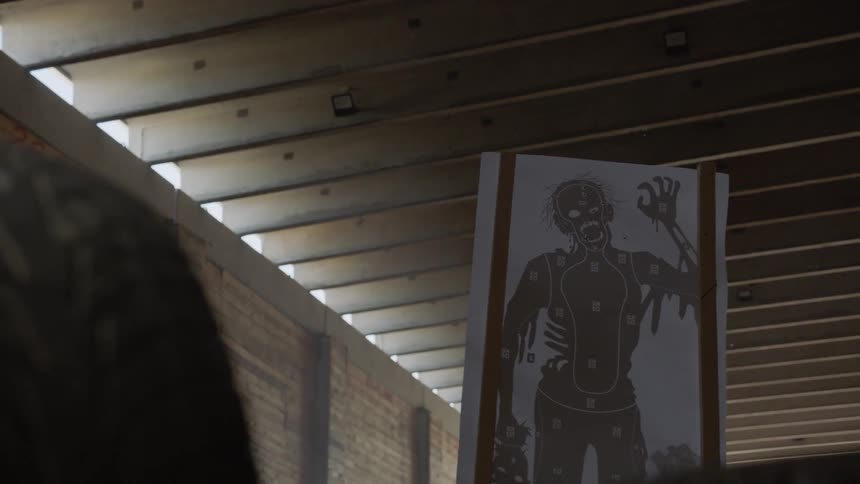 A gun range target hangs near a ceiling inside the range