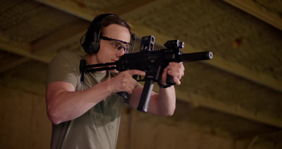 A man aims and shoots a firearm then removes the empty clip