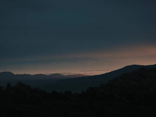 The sun rising over a mountain range landscape