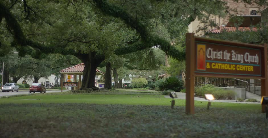 Wooden sign in a natural environment indicating the location next to a street with vehicle traffic